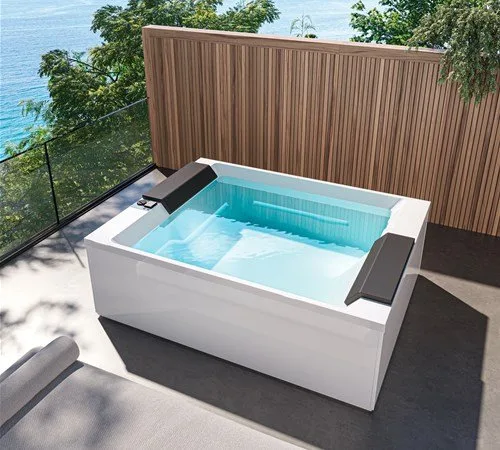 Gruppo Treesse Soul Spa 150 met twee brede kussens, als ingebouwde spa op een terras met houten schutting