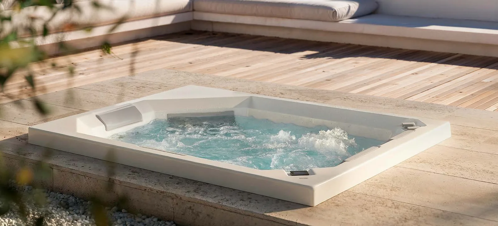 Gruppo Treesse Aquadvance 160, een rechthoekige ingebouwde spa met bruisend water in een houten terras