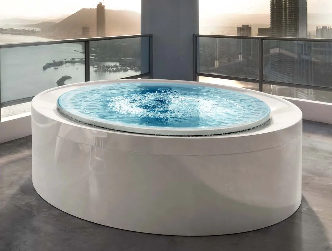 Gruppo Treesse Fusion Spa 200, een ronde witte spa met bruisend water op een balkon met uitzicht over de stad